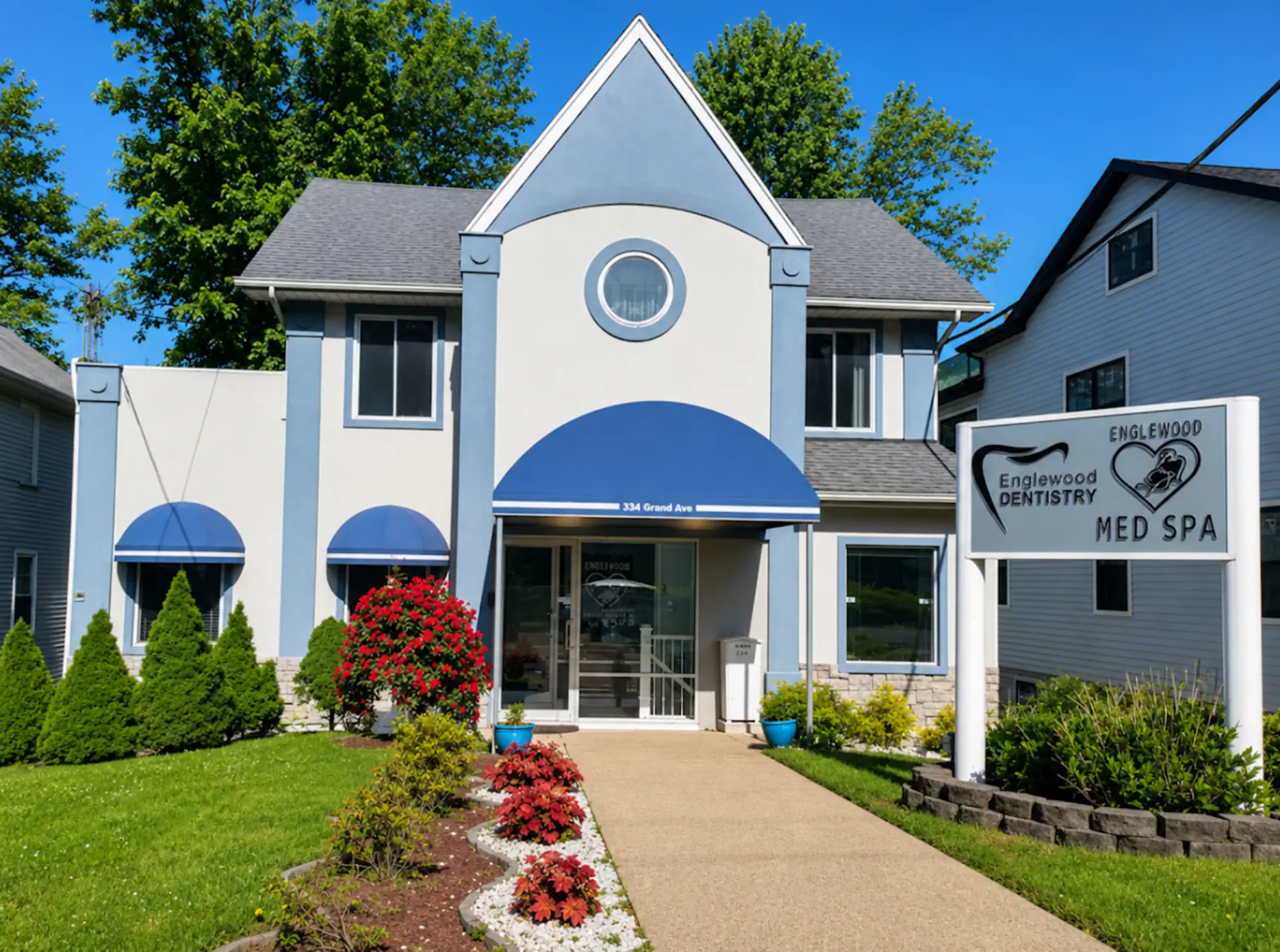 Exterior of Englewood Cosmetic Medical Spa at 334 Grand Ave, Englewood NJ, with blue awnings and street signage