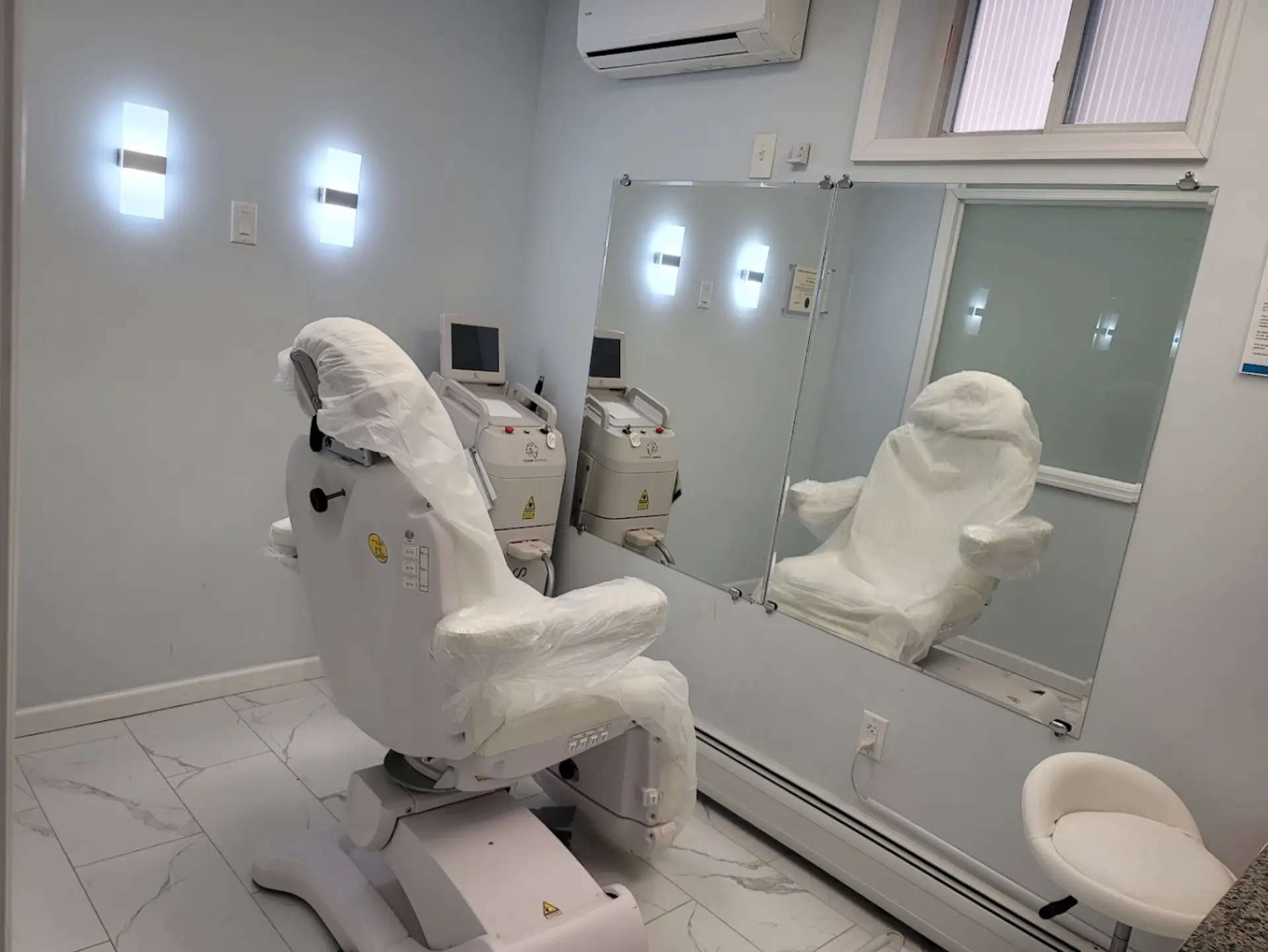 Private treatment suite with a medical laser platform, procedure chair and full-length mirror in Bergen County, NJ